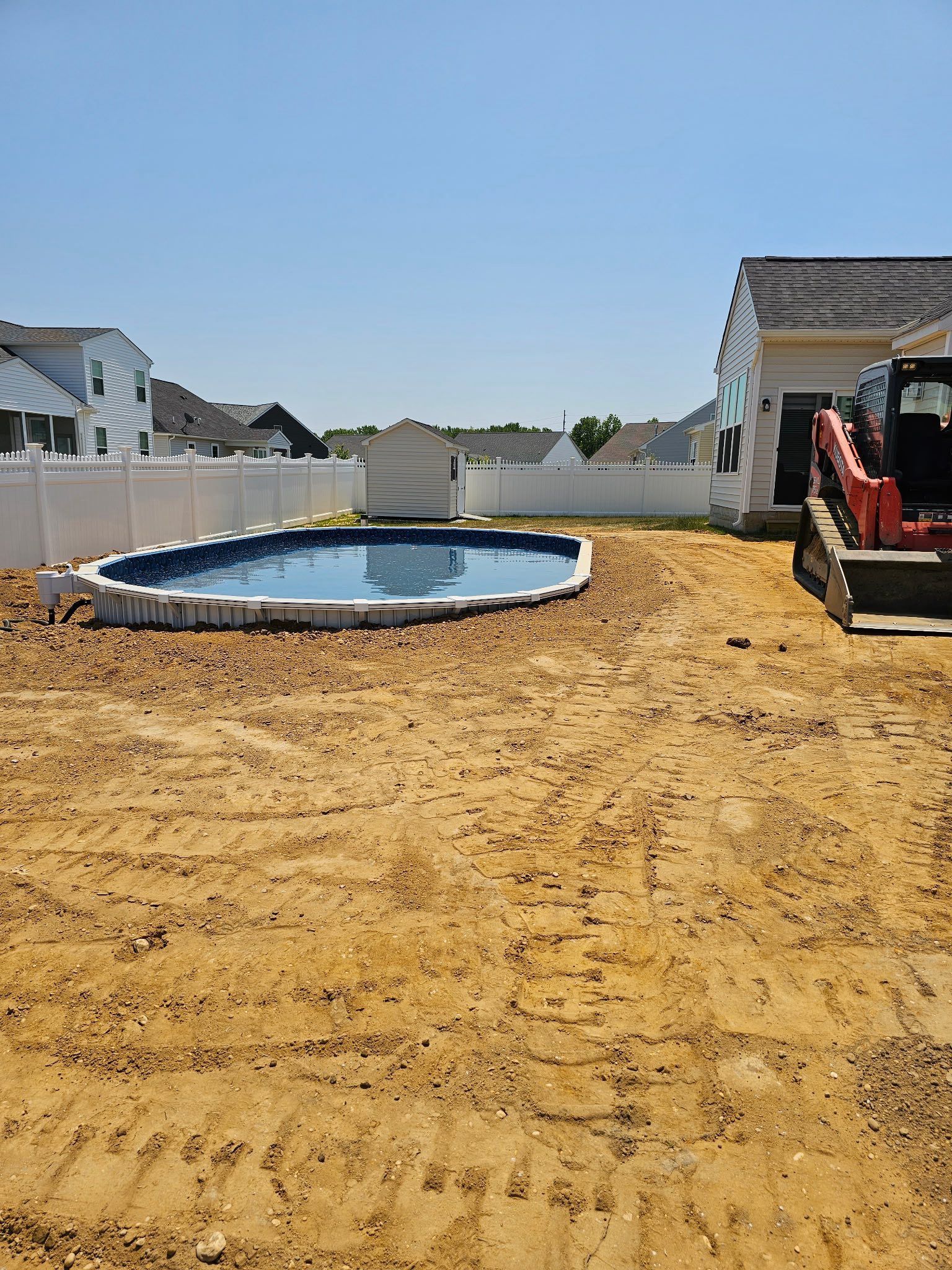 A swimming pool is being built in the backyard of a house.