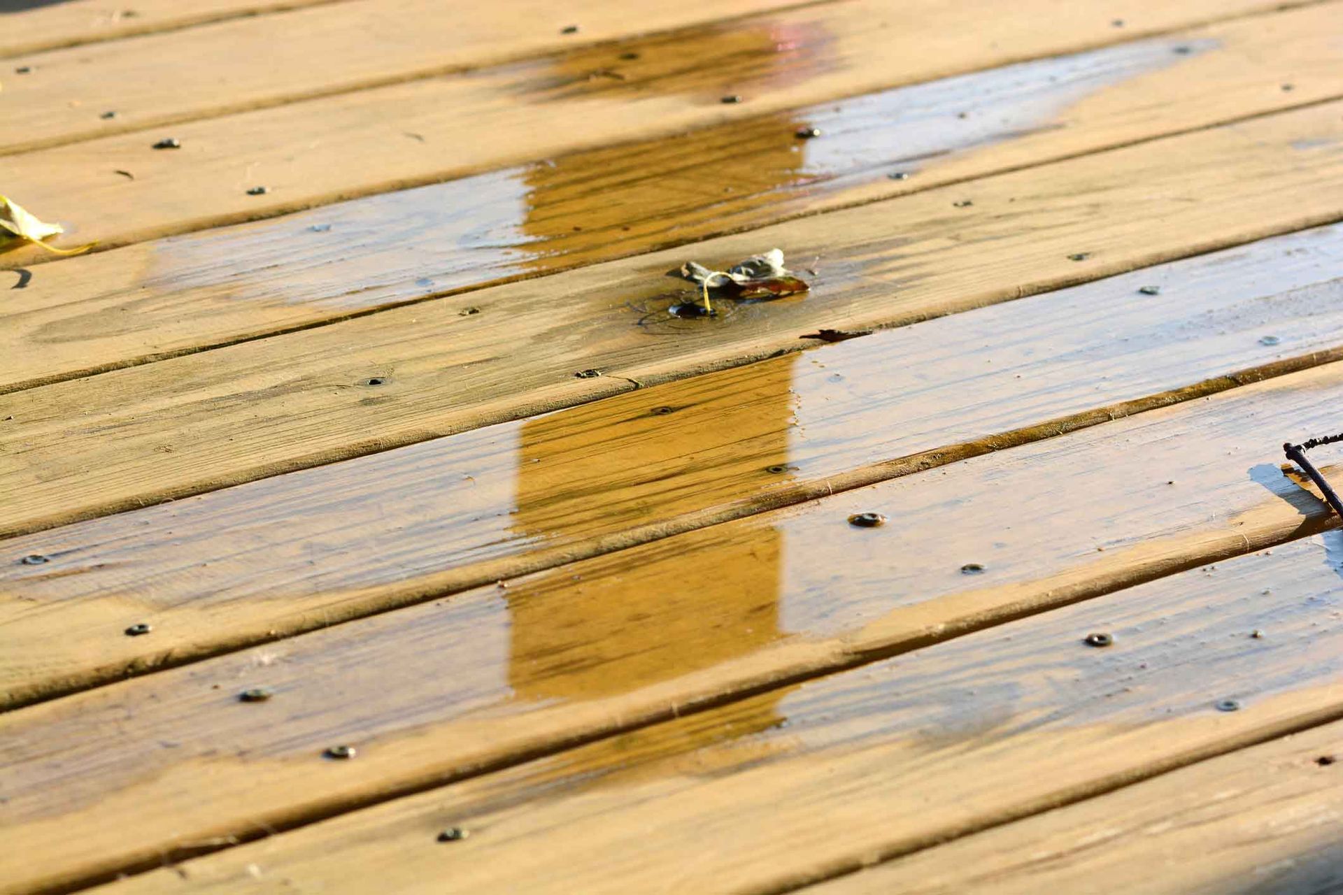 A close up of a wooden deck with water on it.