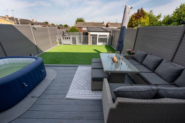 A patio with a couch , table , and a hot tub.