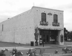 Lompoc Valley Chamber of Commerce building with stucco facade; arched windows and entrance, date 1924 above door.