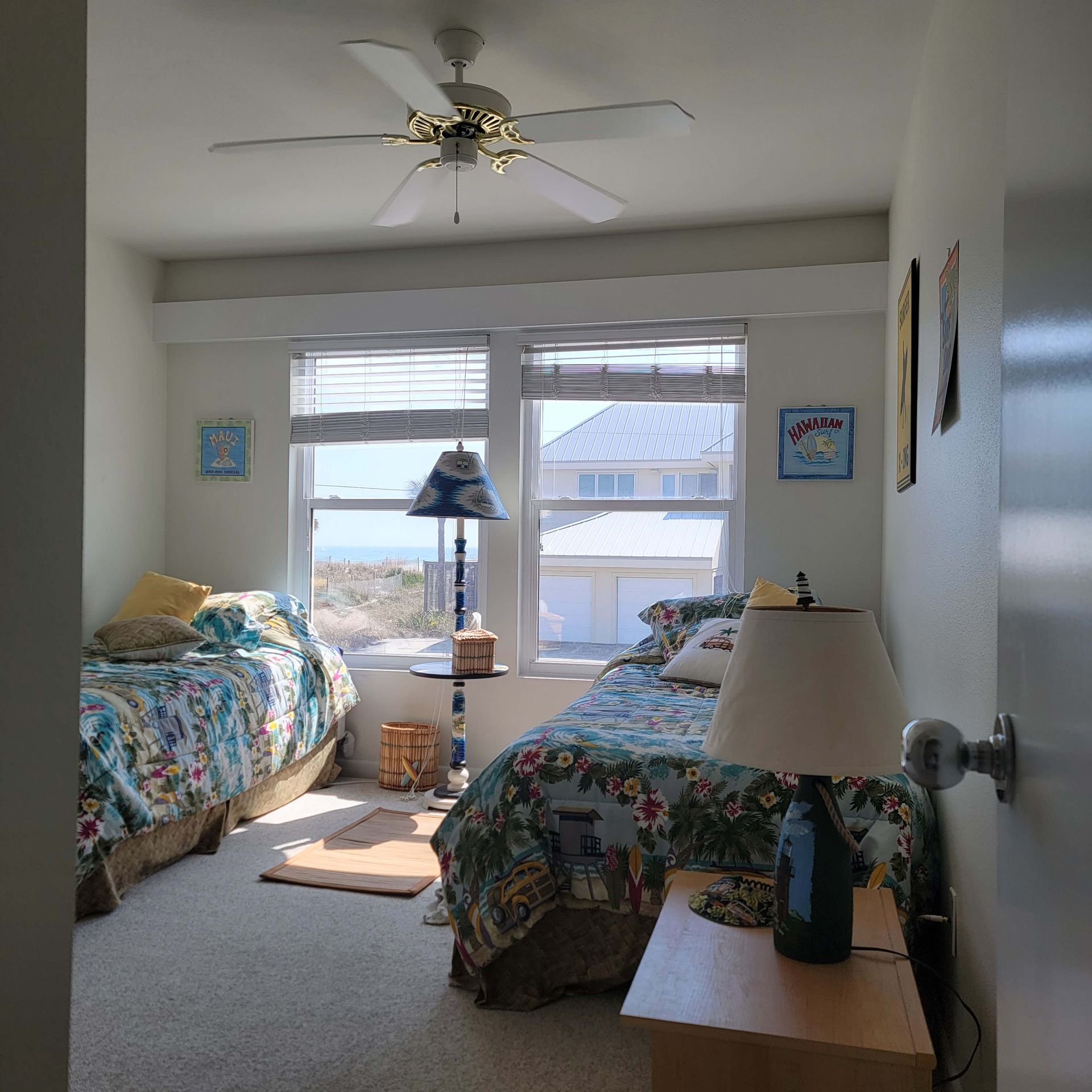 A bedroom with two beds and a ceiling fan