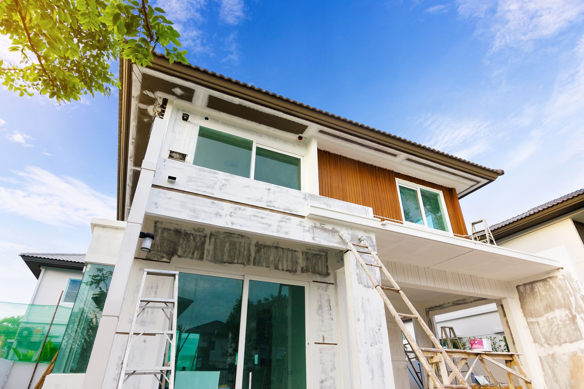 A house under construction with a ladder on the side of it.