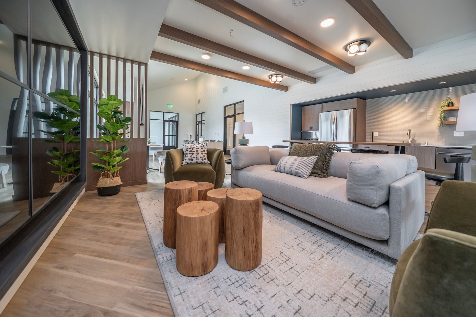 Living room with gray sofa, wooden coffee tables, and olive green armchairs.