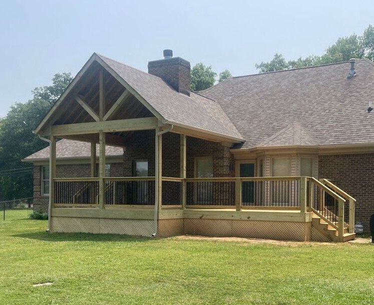 A wooden deck with a metal railing and a house in the background.