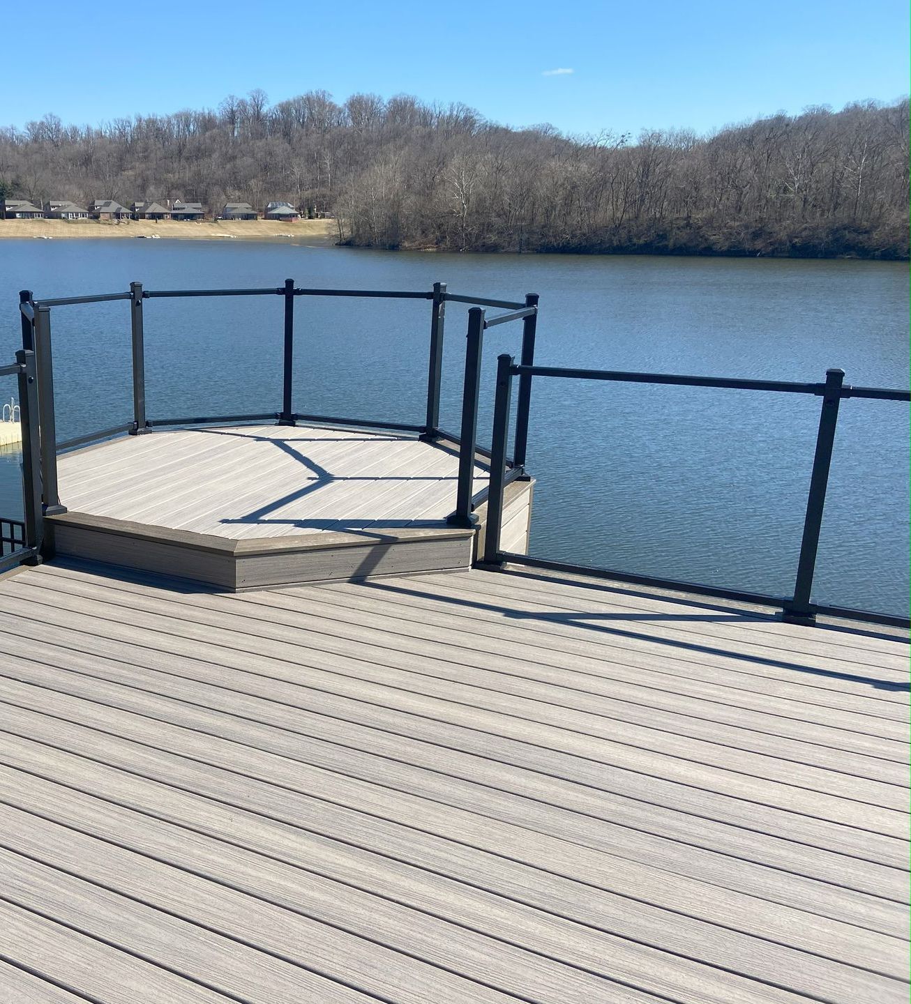 A white fence is sitting on top of a wooden deck.