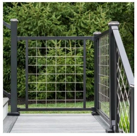 A fence with a grid of squares on it is surrounded by trees.