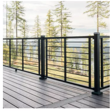 A deck with a black railing and a view of trees