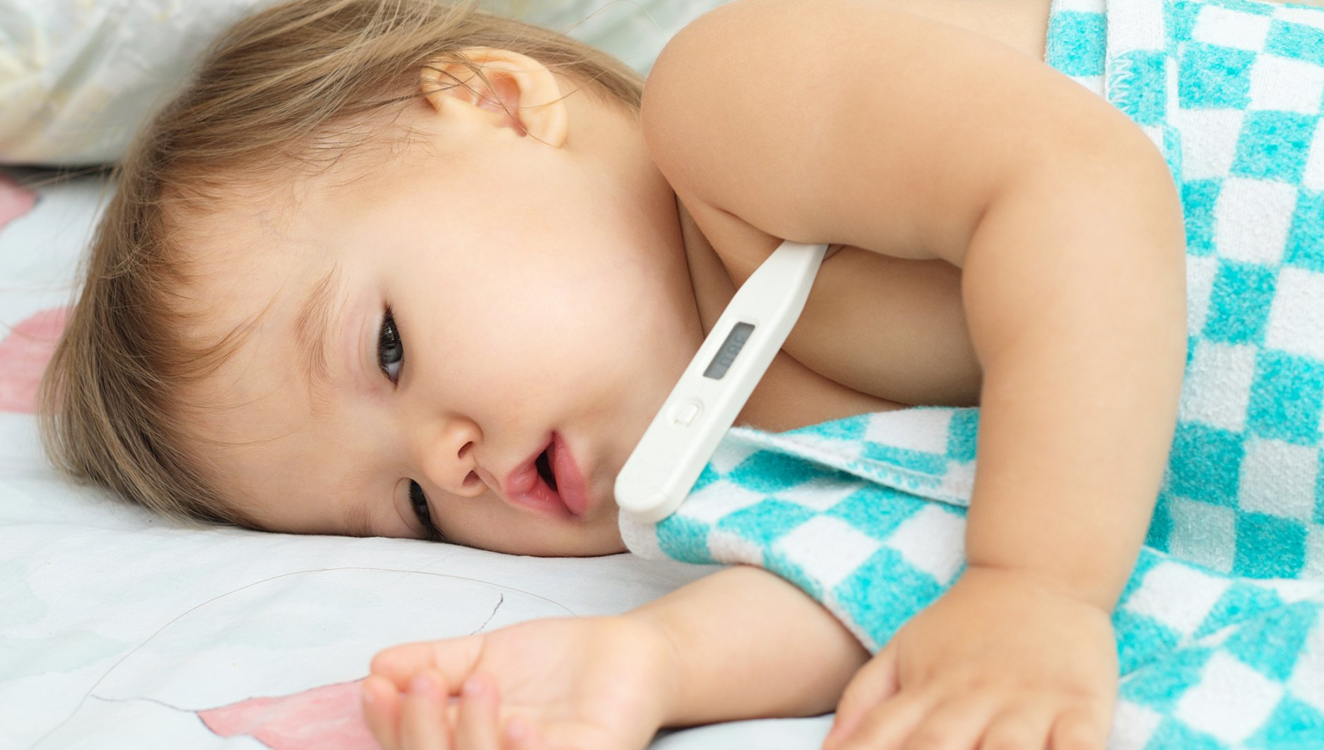 a baby is laying down with a thermometer in his mouth