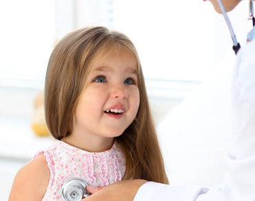 a little girl is being examined by a doctor with a stethoscope .