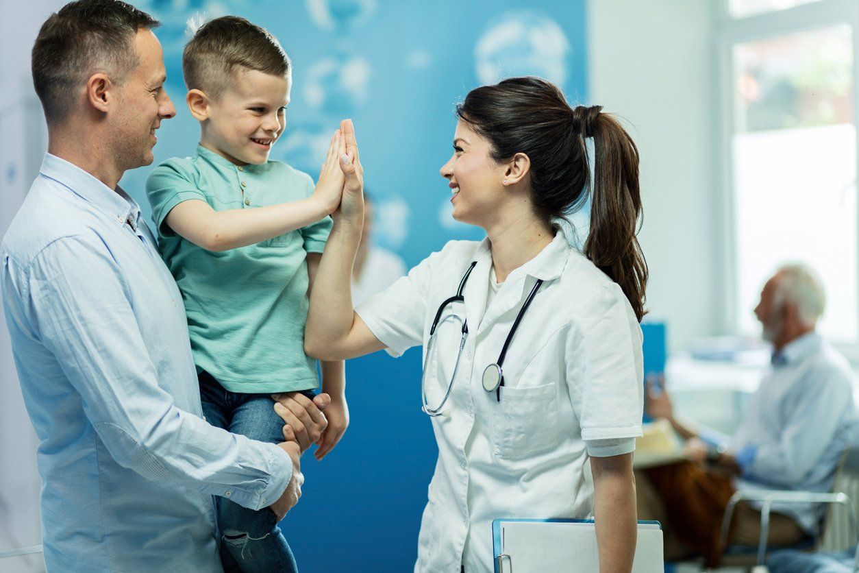 a little boy gives a high five to a doctor