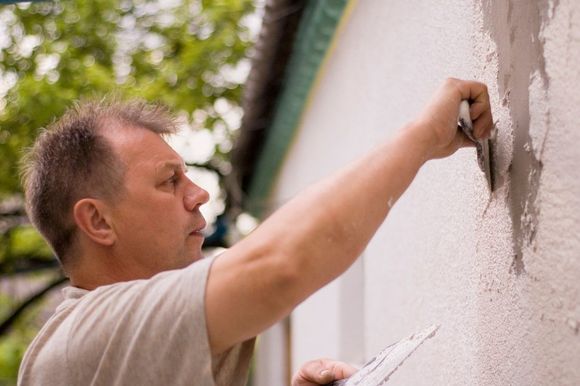 A man repairing stucco on the exterior of a home in Grand Junction Colorado