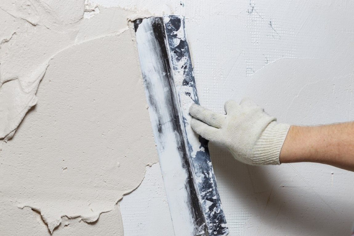 Close up image of a person's hand with stucco trowel in Grand Junction Colorado