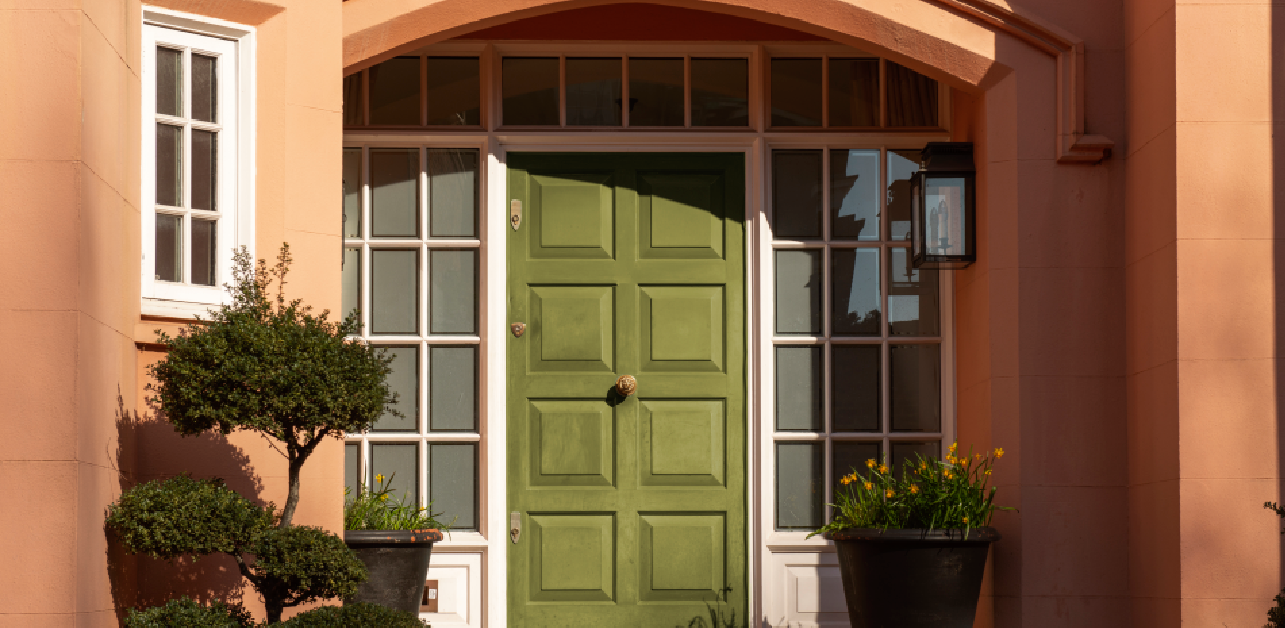 Green insulated entry door on peach-colored home