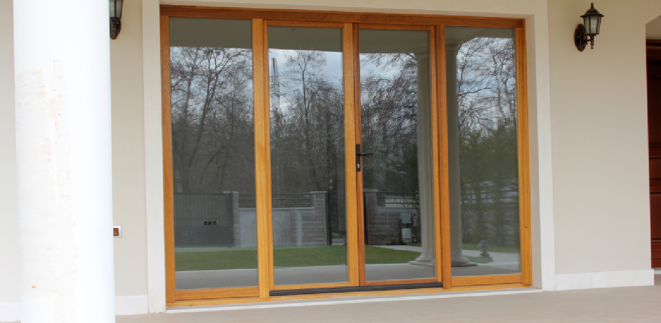 Wood-framed sliding glass patio door in winter