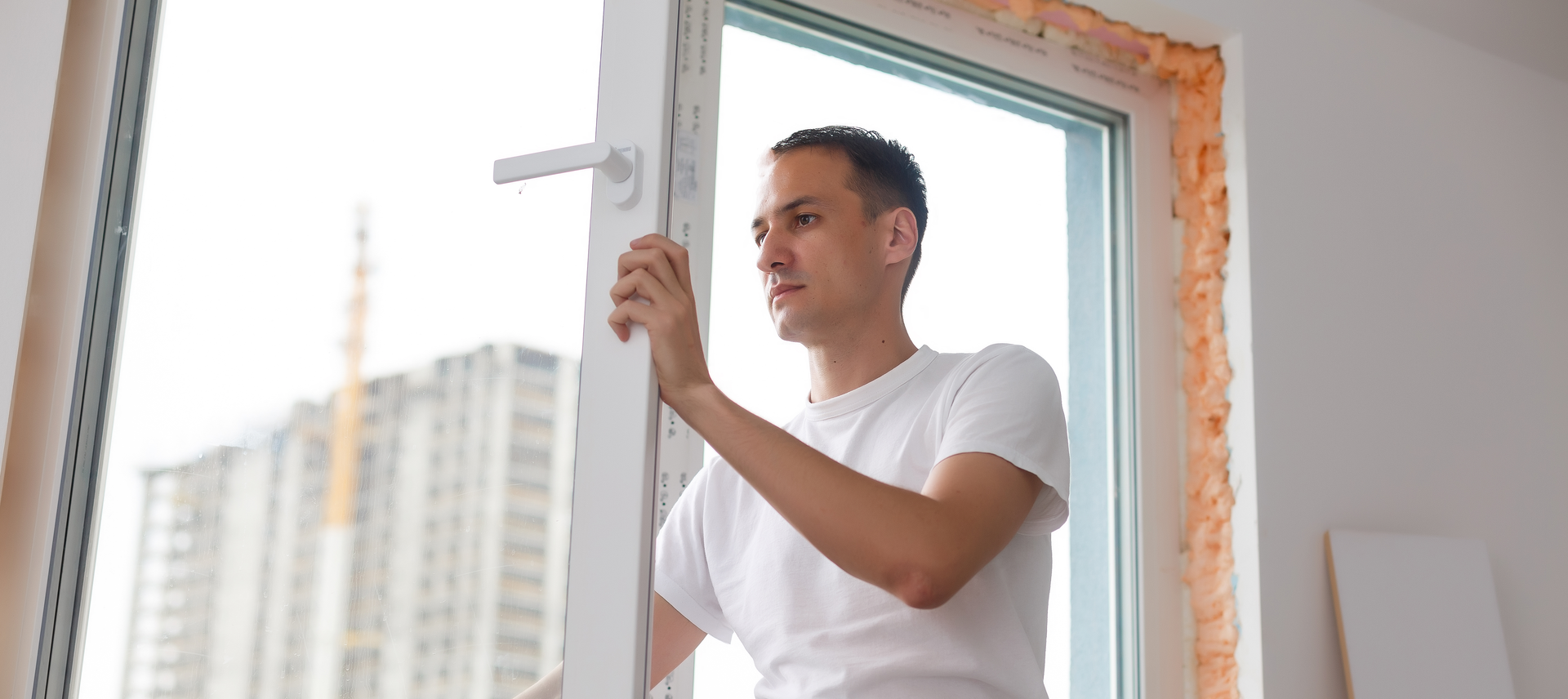 Professional installer working on custom arched window installation with specialized tools