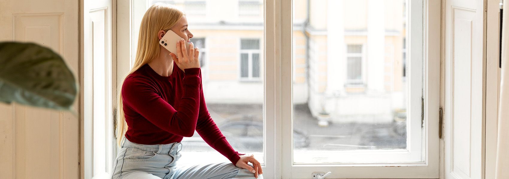 Person enjoying natural light through energy-efficient Low-E double-pane windows in bright home.