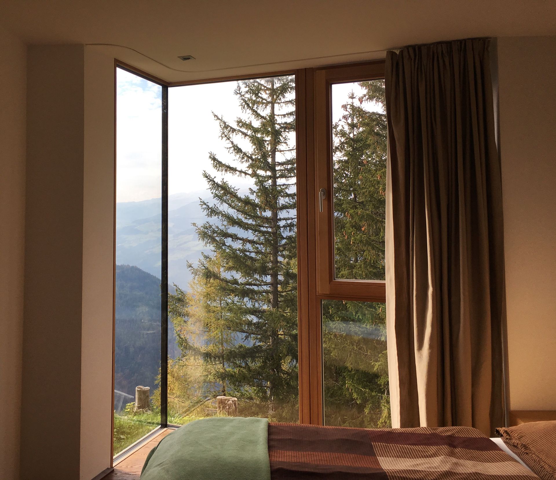 Large window in Colorado bedroom overlooking pine trees and mountains