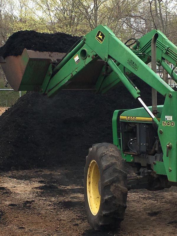 Our tractor unloading soil for our landscaping service