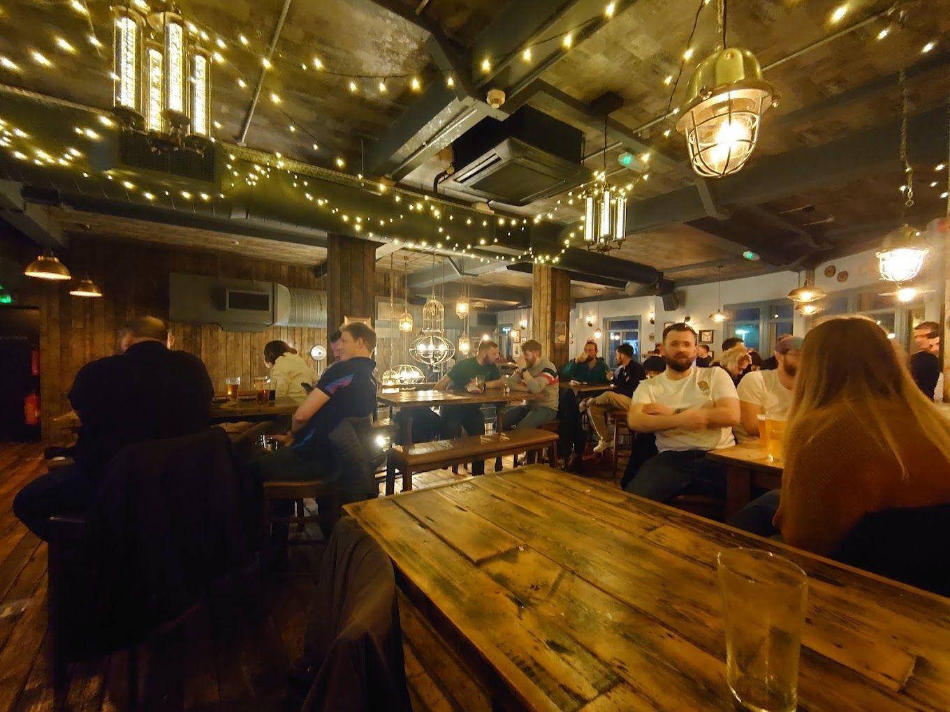 London Road Brew House, Southampton, nightime view showing industrial elements of the pub, along with pendant lighting and industrial pendant lights.