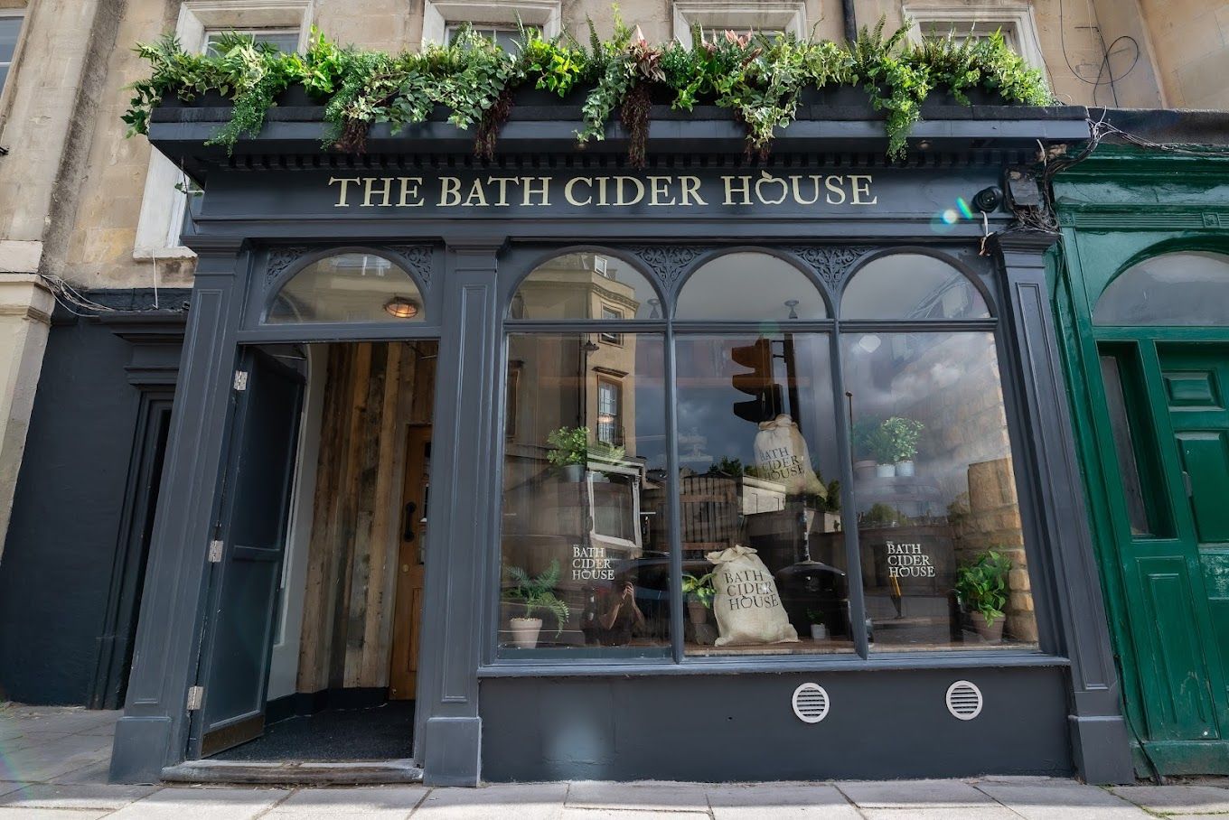 Bath Cider House, external view showing painted timber shopfront and feature planting above.