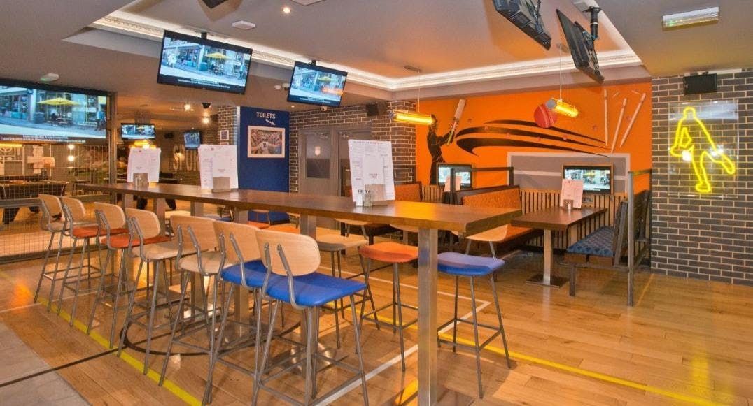 Sports Bar & Grill, Old Street, London, central vertical seating area showing TV's with sporting events.