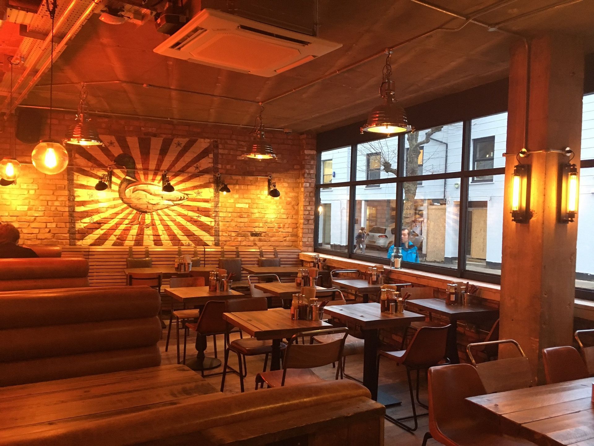 Chicken Society, Finchley, London, view showing rear dining area with feature mural painted to reclaimed brickwork.