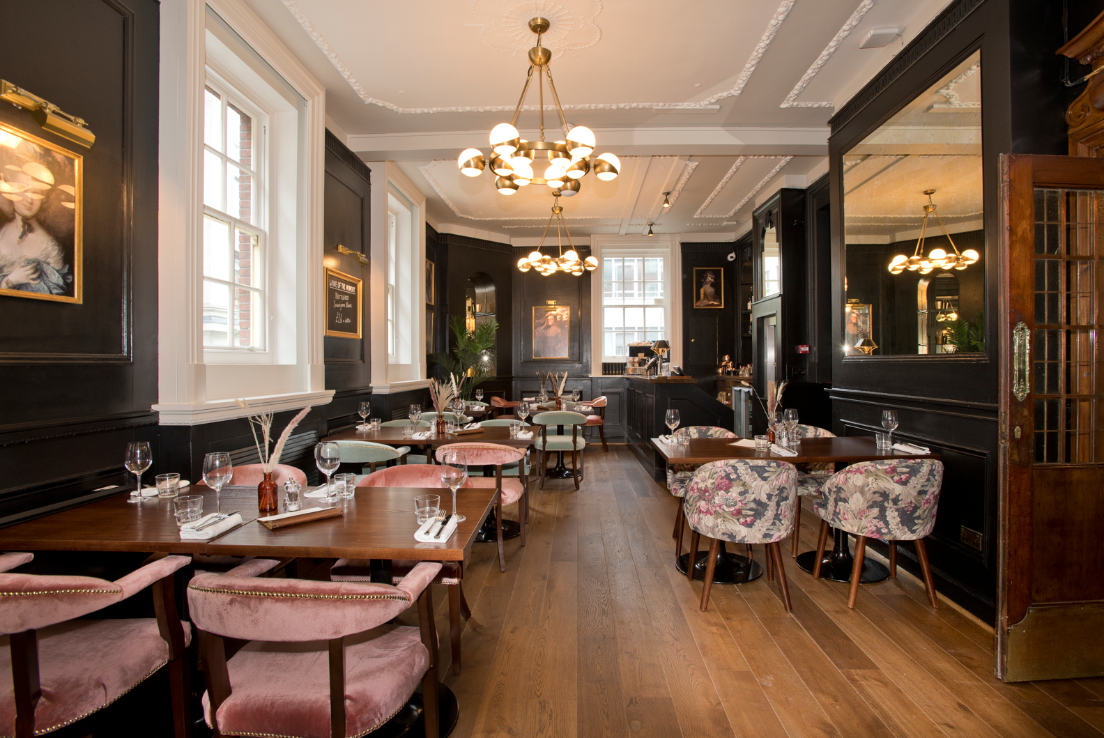The Duchess, Marylebone, London, first floor dining area showing timber flooring and opulent chandelier.
