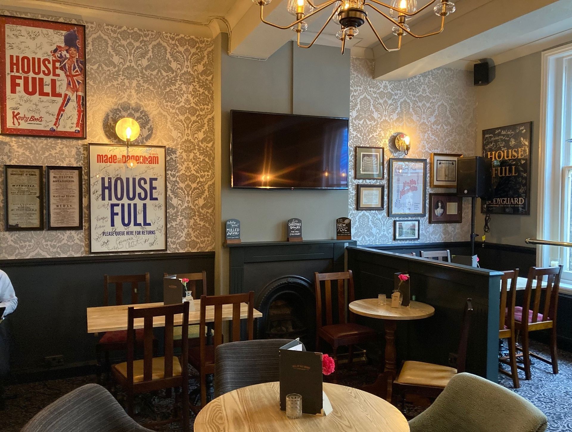 Nell of Old Drury, Covent Garden, London, first floor seating/dining area showing artwork, seating area, and chandelier.