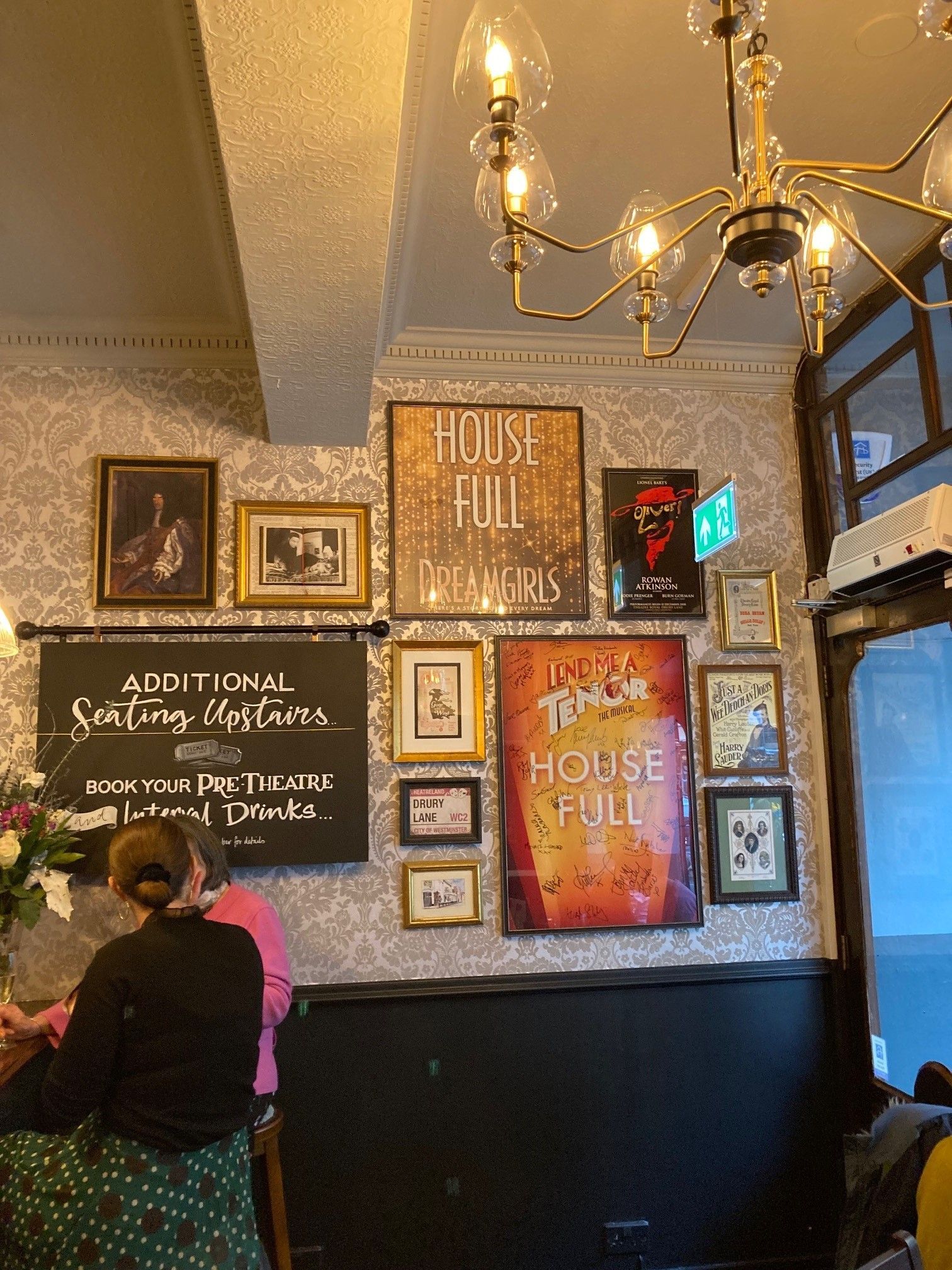 Nell of Old Drury, Covent Garden, London, looking towards main entrance doorway and showing wallpapered wall with artwork.
