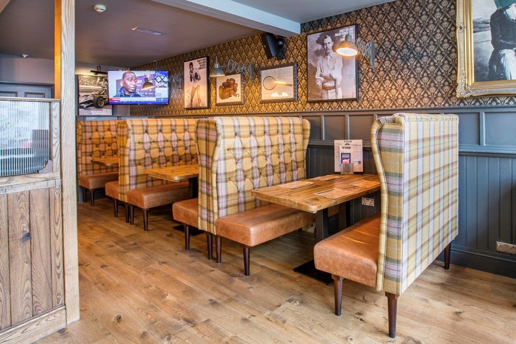 The Old Library, Leamington Spa, dining area showing booth seating, timber flooring and traditional decoration.