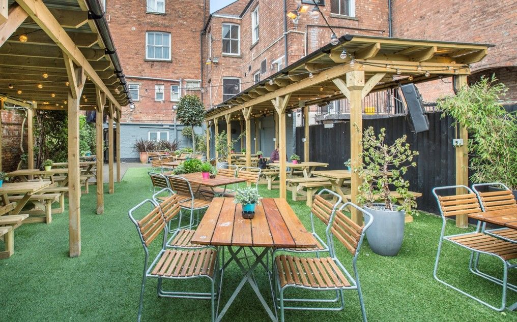The Old Library, Leamington Spa, rear garden area with timber pergolas covering seating area, and artificial grassed seating area.