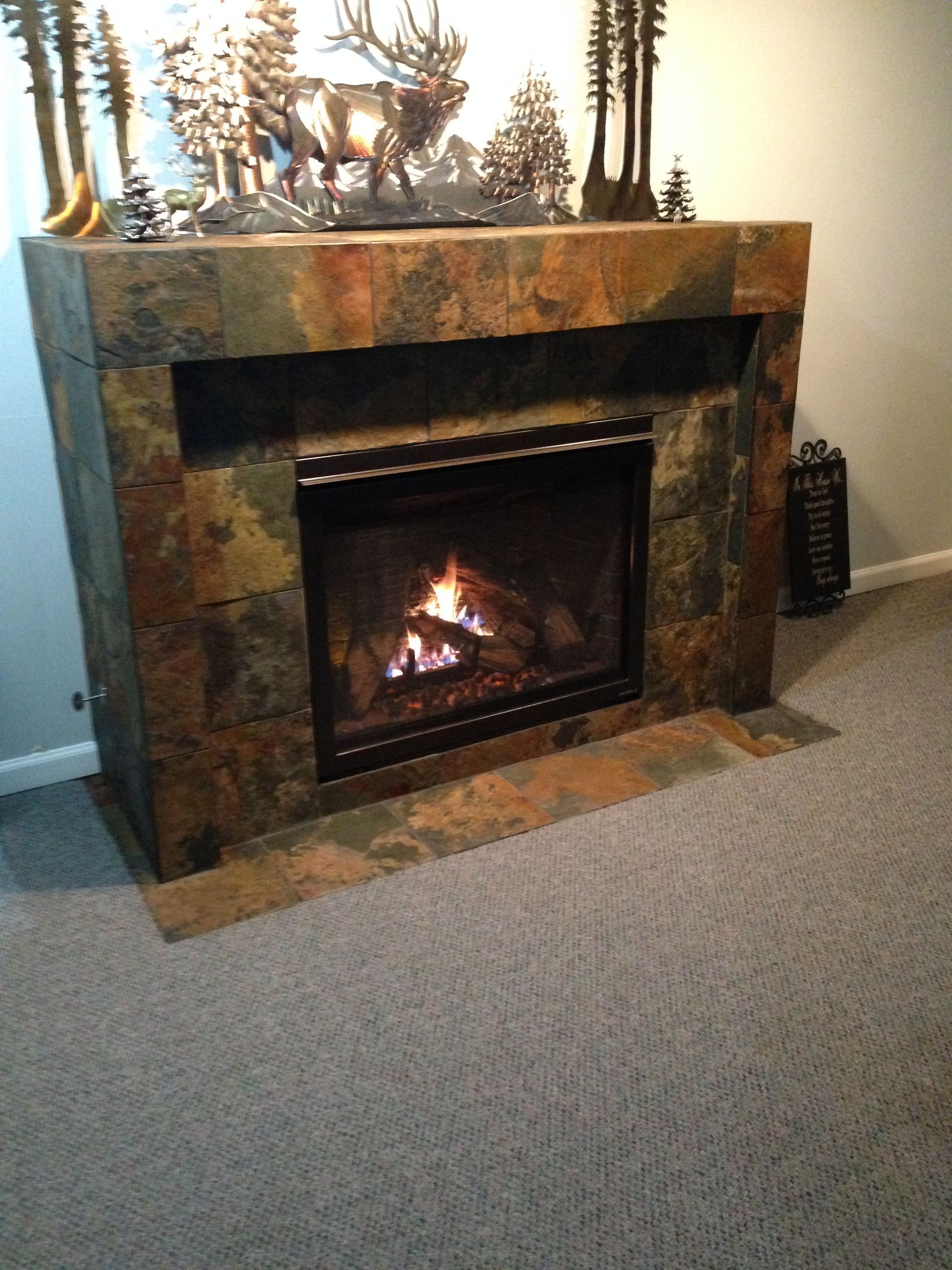 A fireplace with a deer statue on top of it
