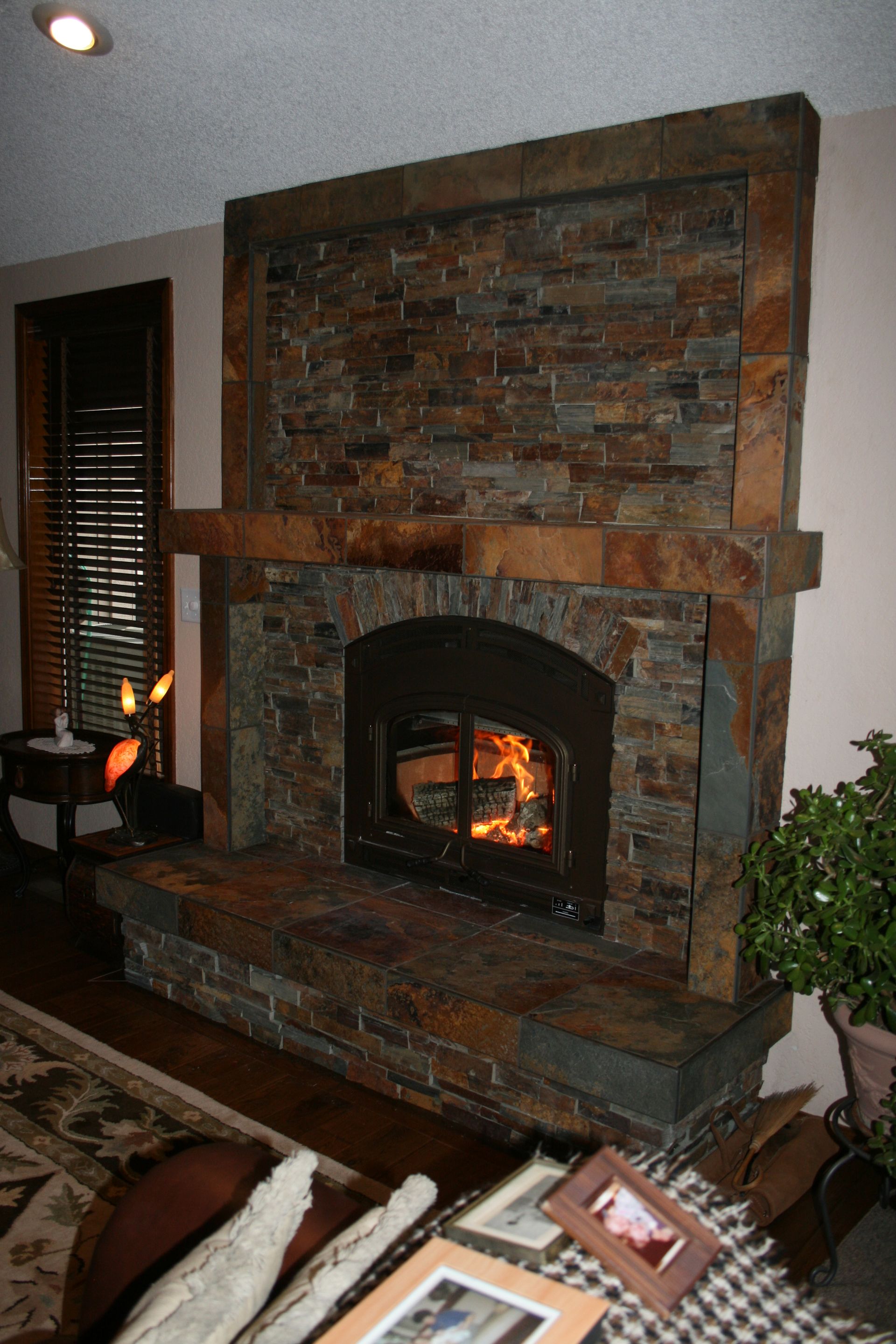A living room with a fireplace and a picture on the couch