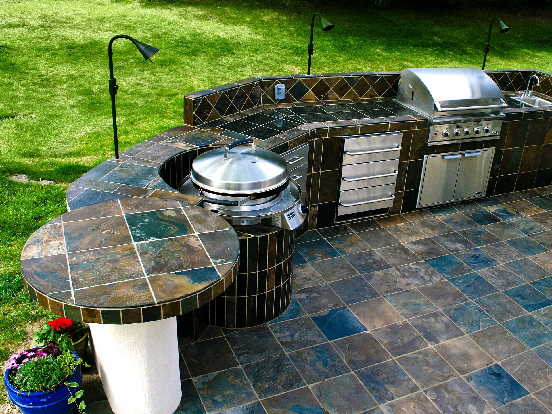 An outdoor kitchen with a grill and a table