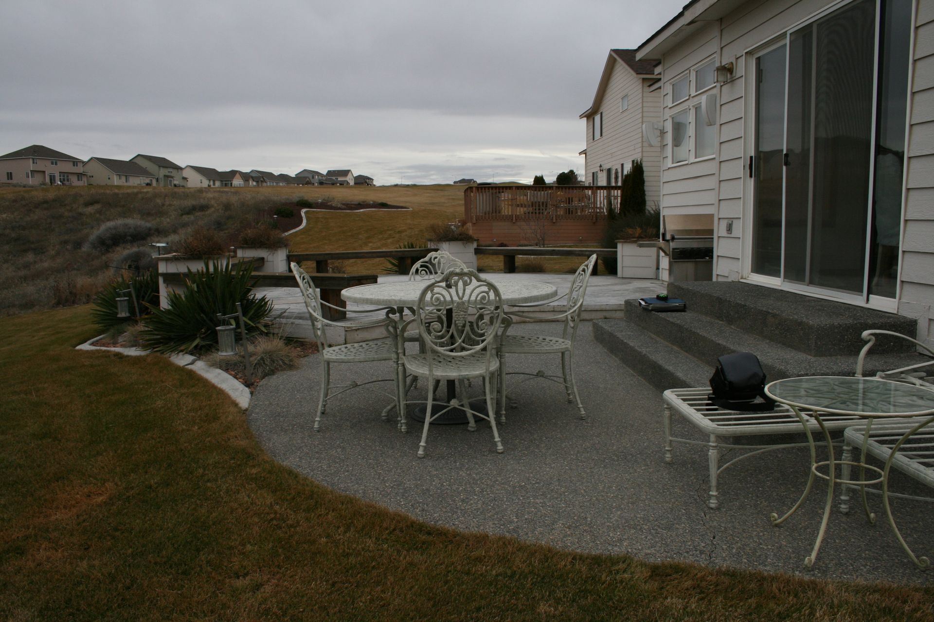A patio with a table and chairs in front of a house