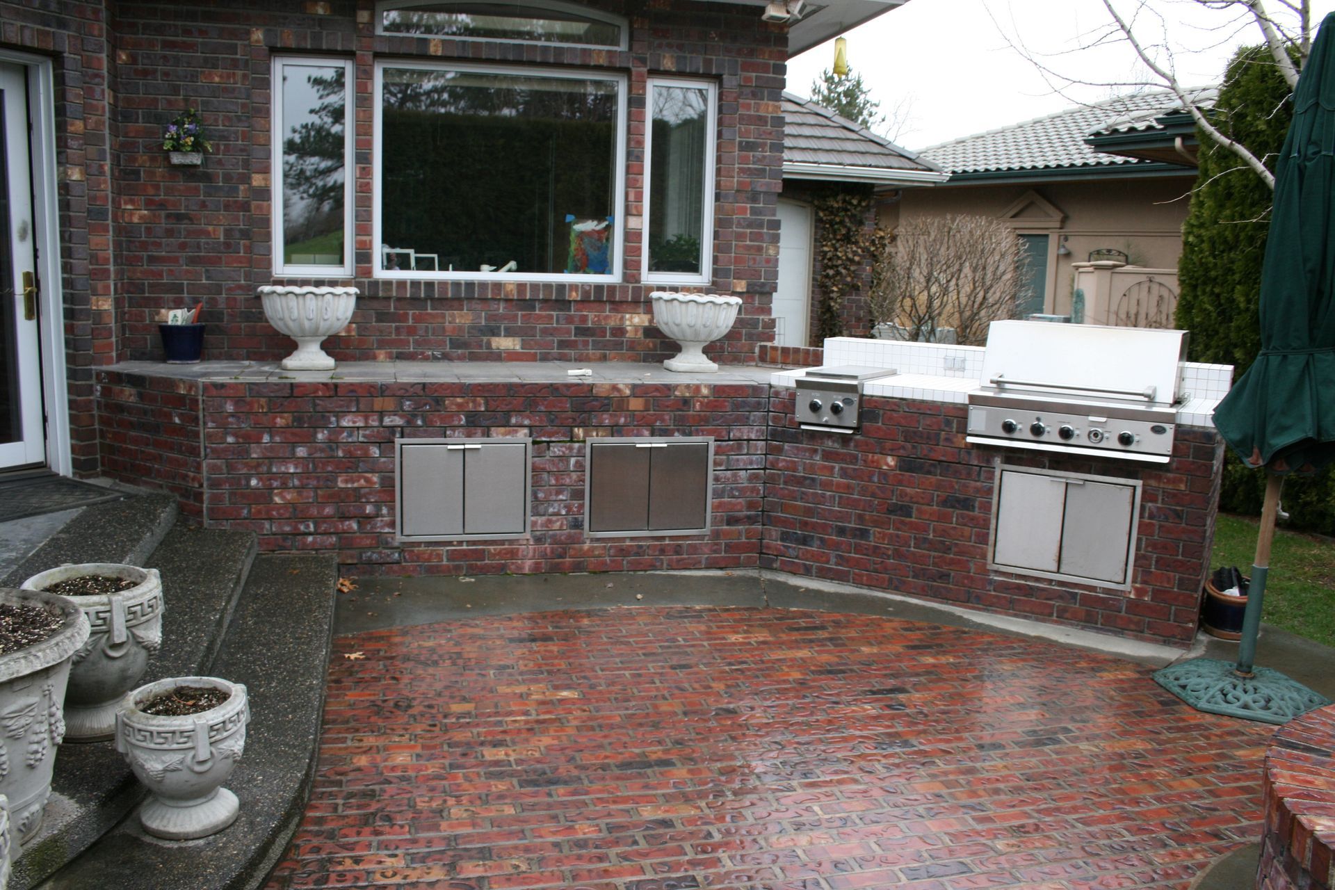 A brick house with a patio area and a grill