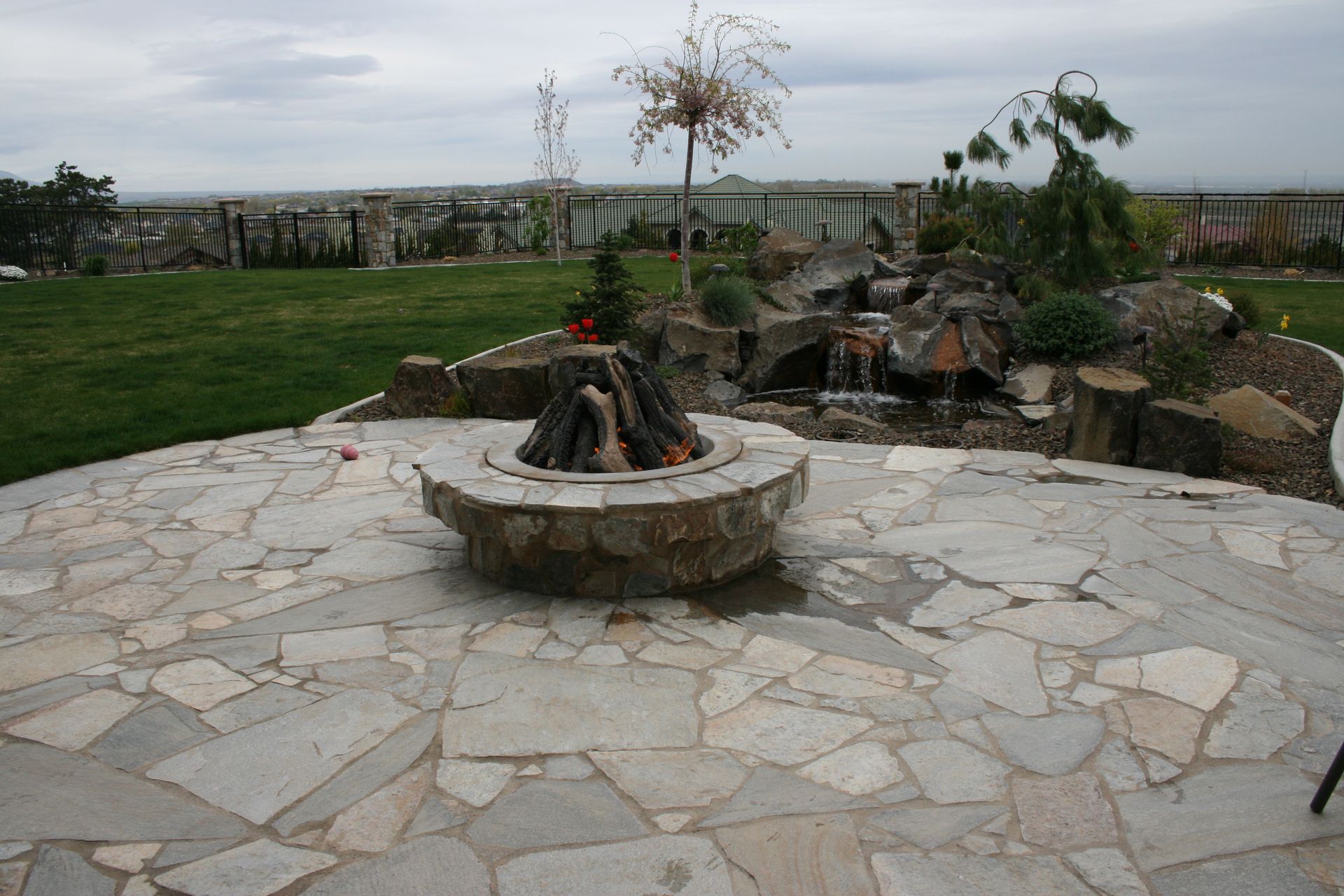 A fire pit in the middle of a stone patio