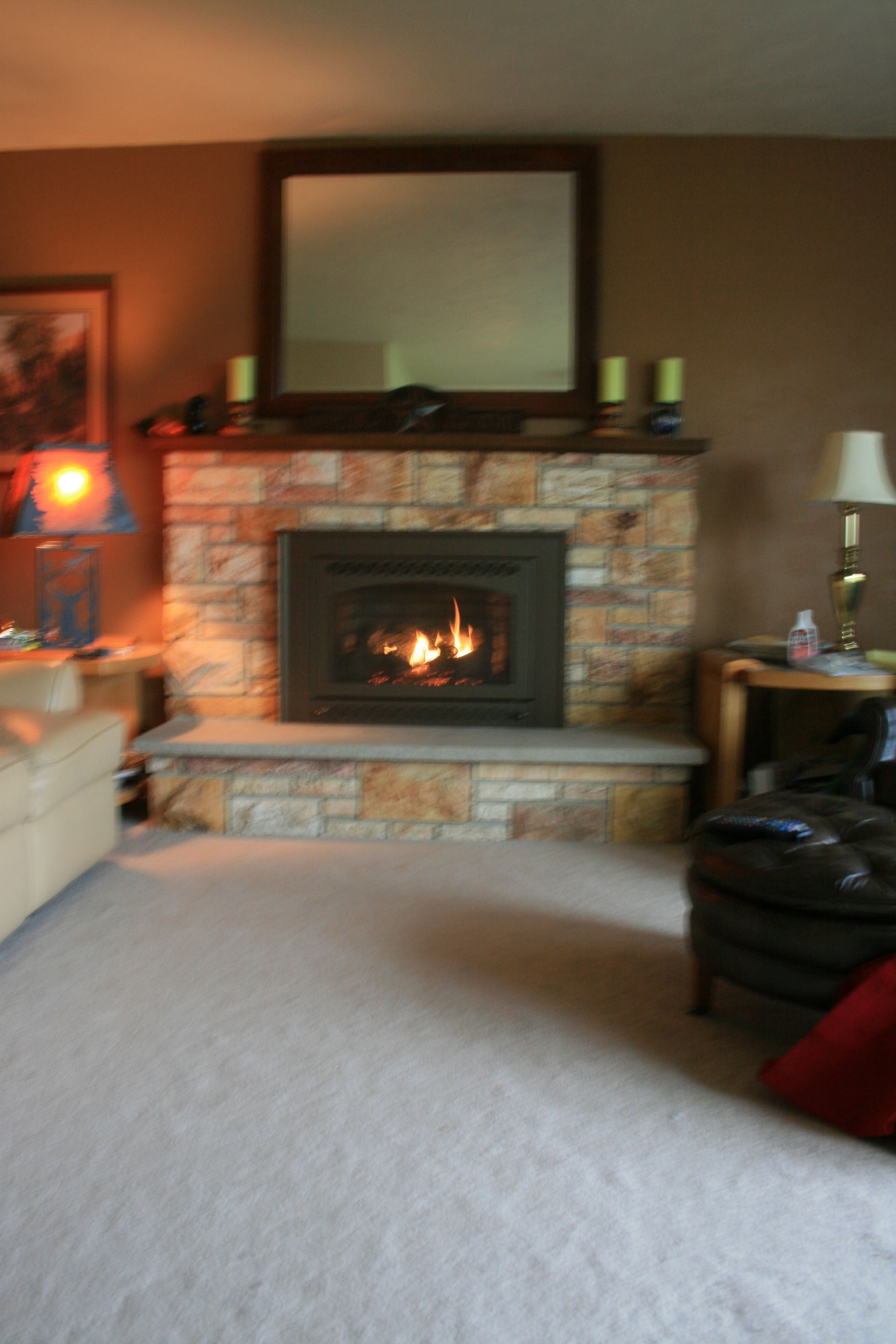 A living room with a fireplace and a mirror
