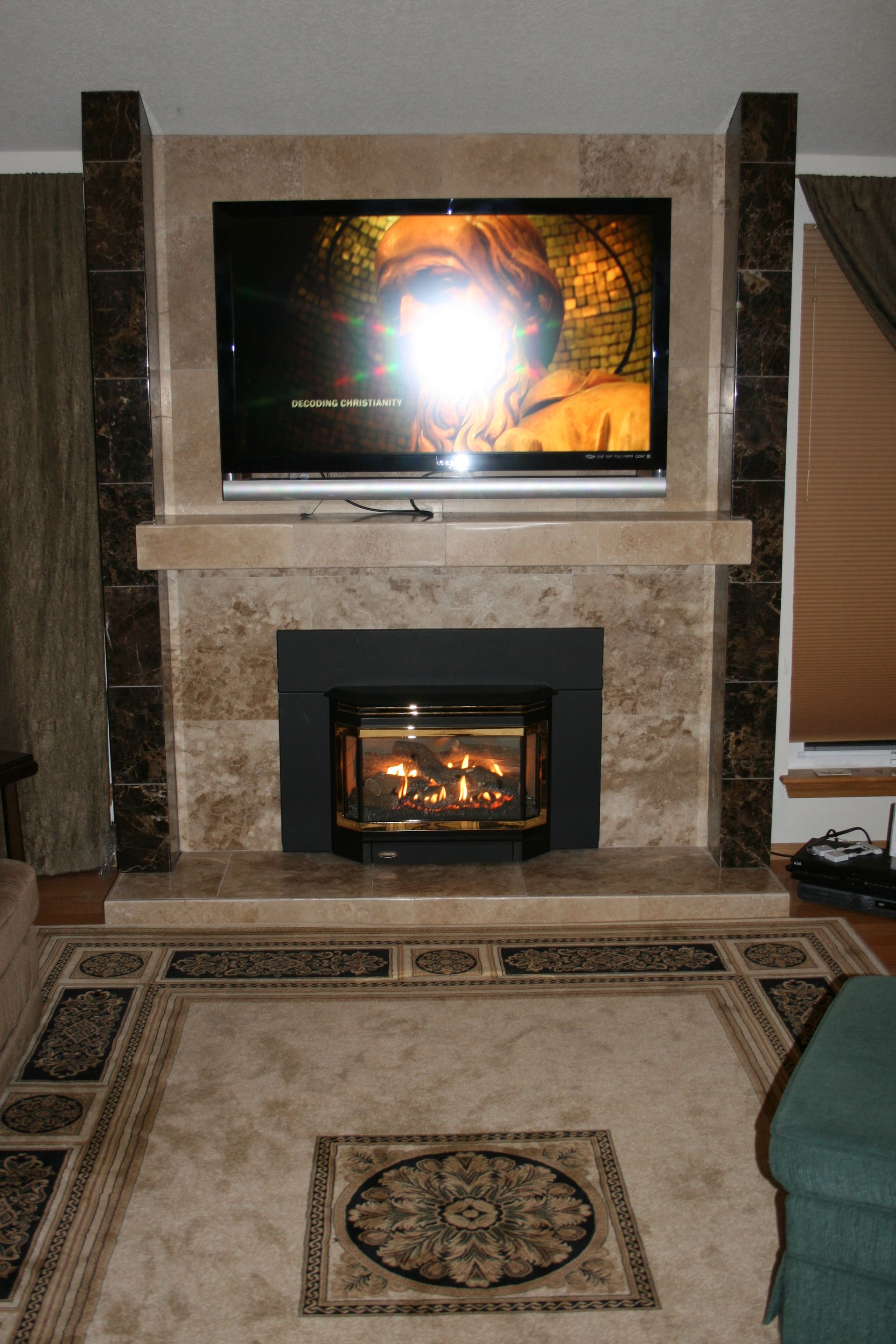 A living room with a fireplace and a flat screen tv