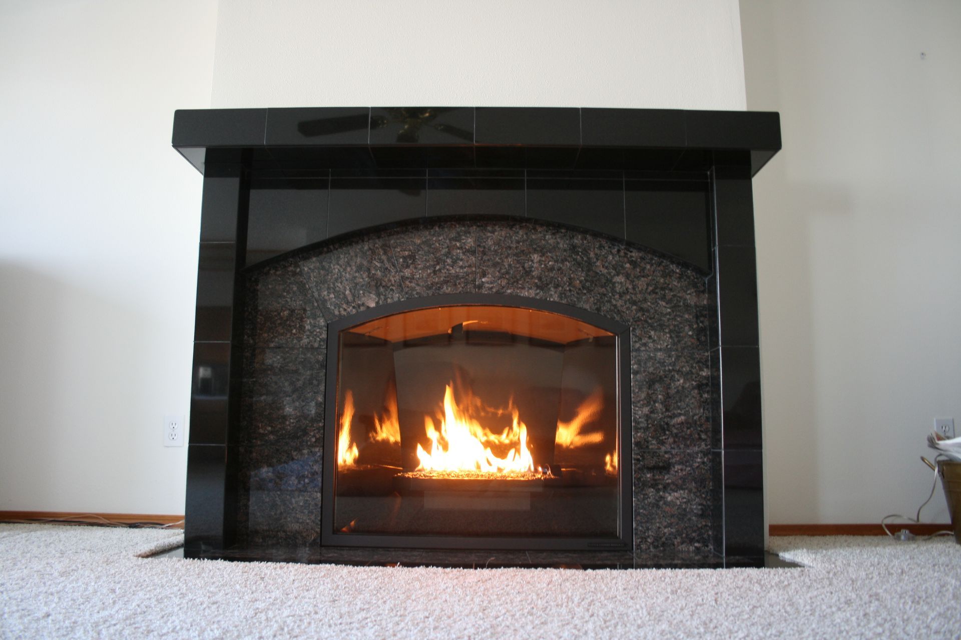 A fireplace is lit up in a living room