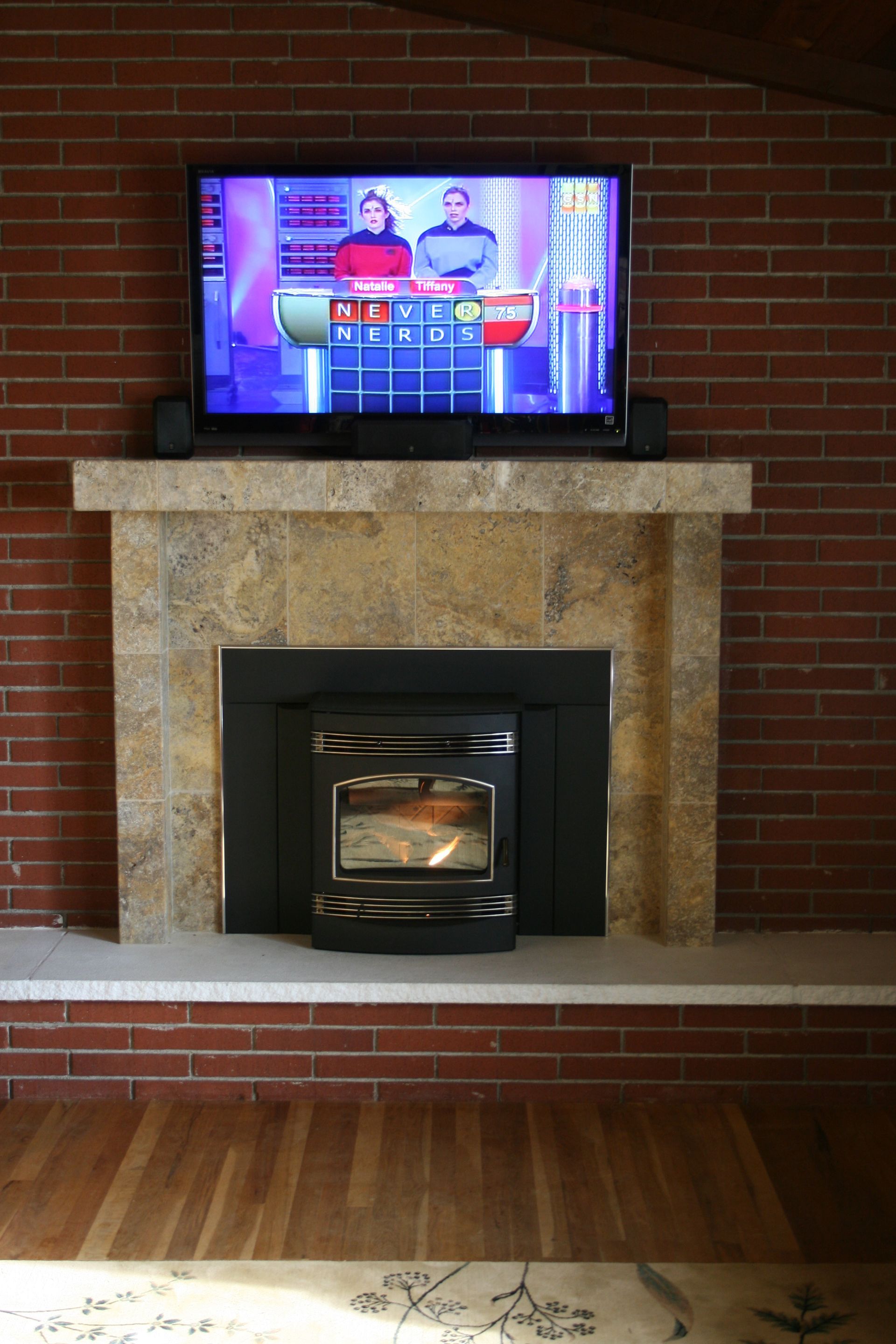A fireplace with a flat screen tv on top of it