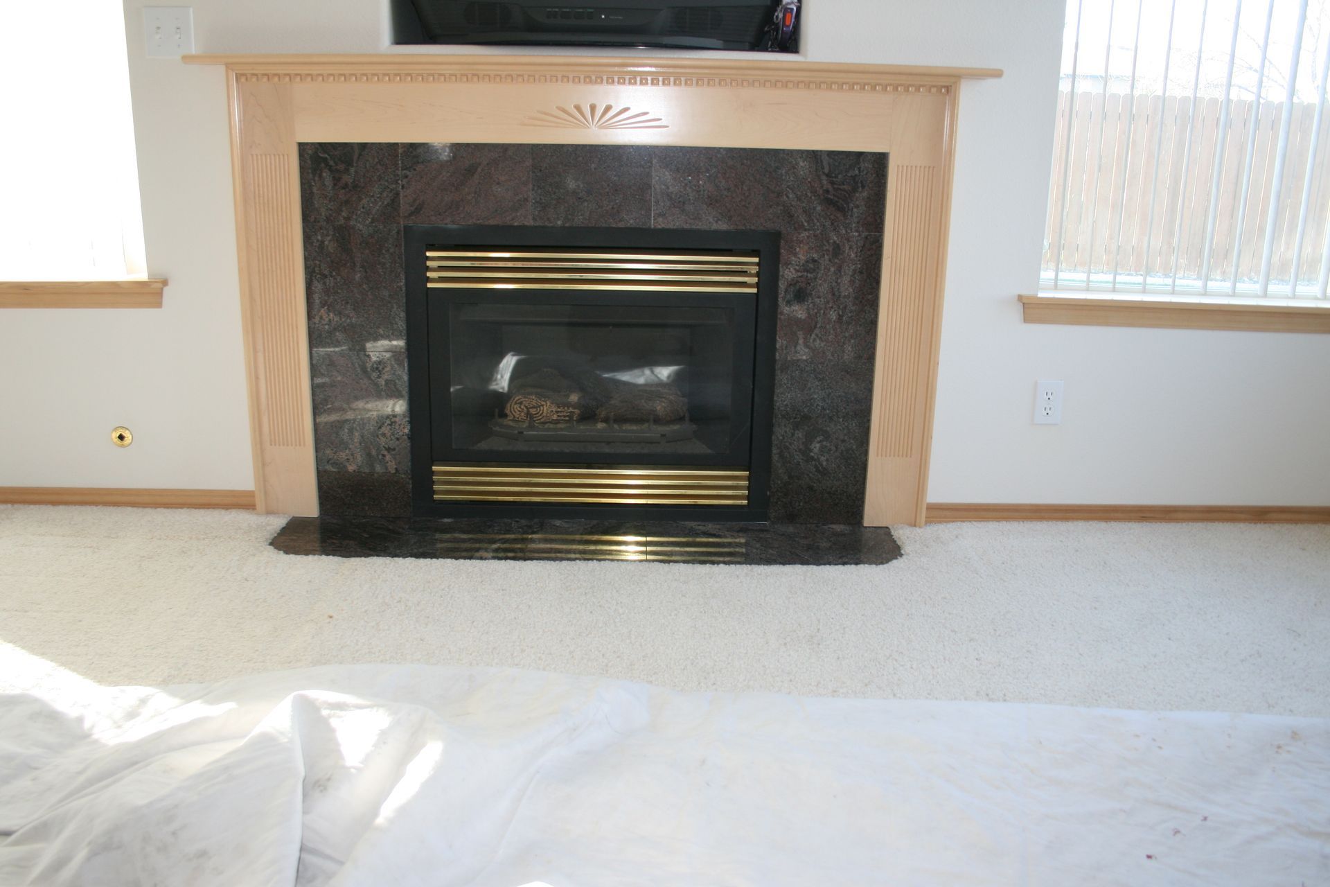 A fireplace in a living room with a television above it