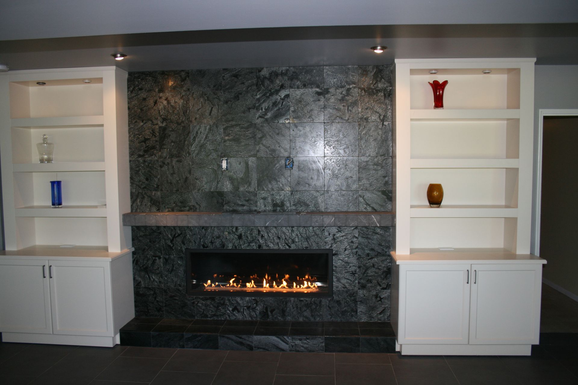 A fireplace surrounded by shelves and cabinets in a living room