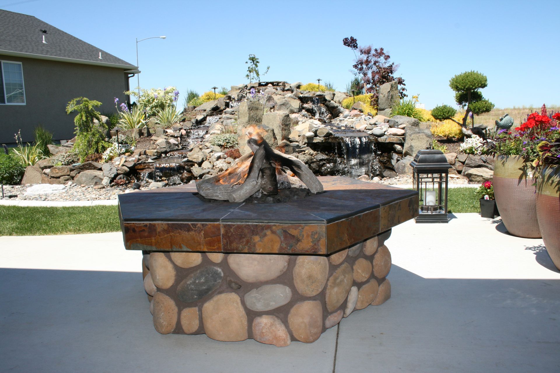 A fire pit with a waterfall in the background
