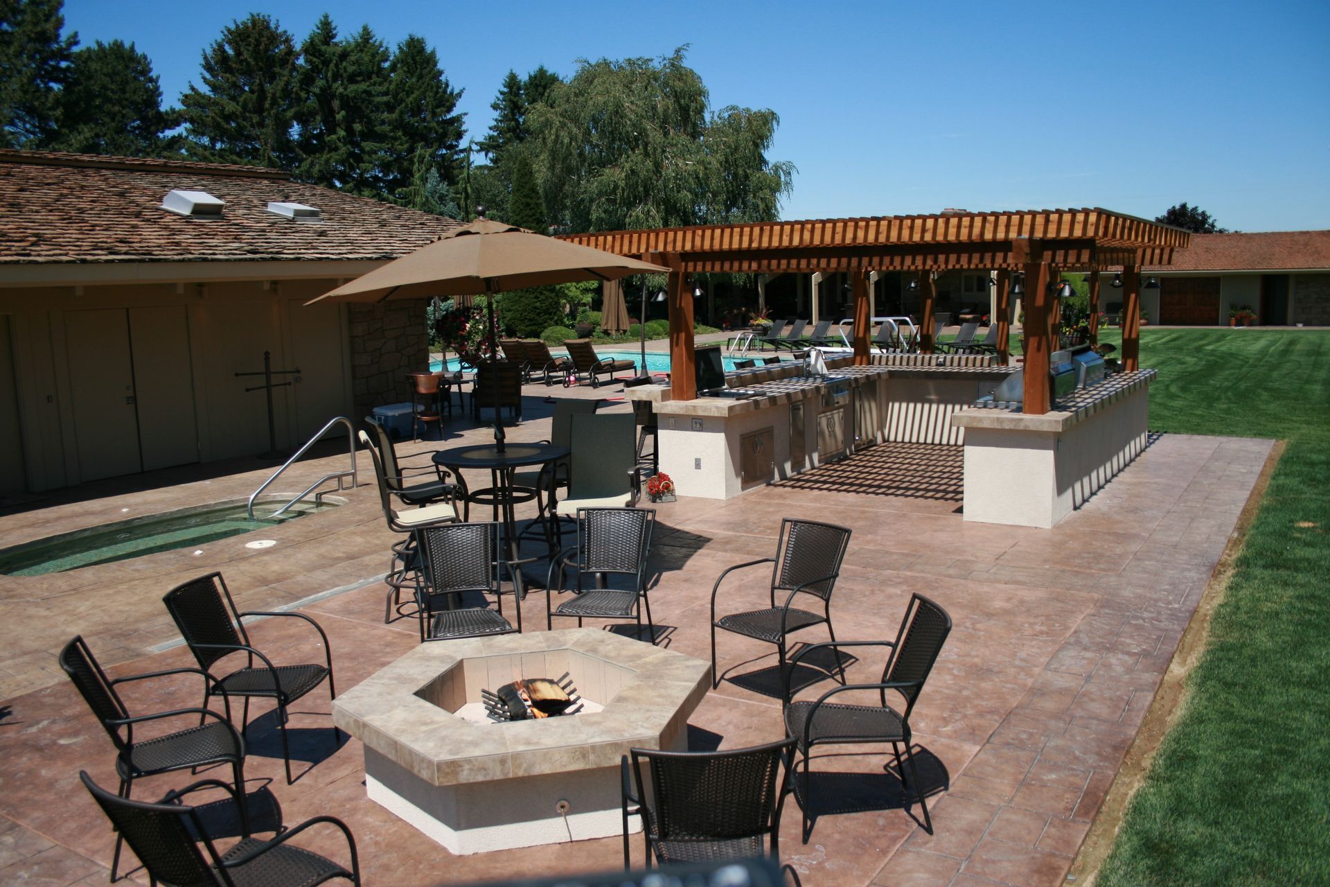 A fire pit is surrounded by chairs and tables
