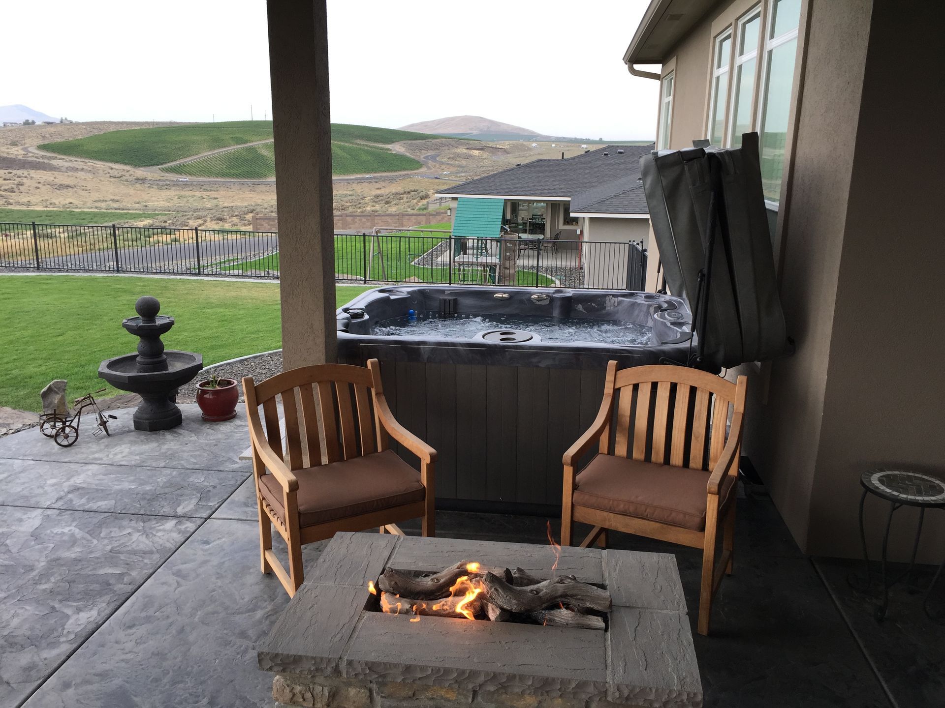 A patio with a fire pit and a hot tub