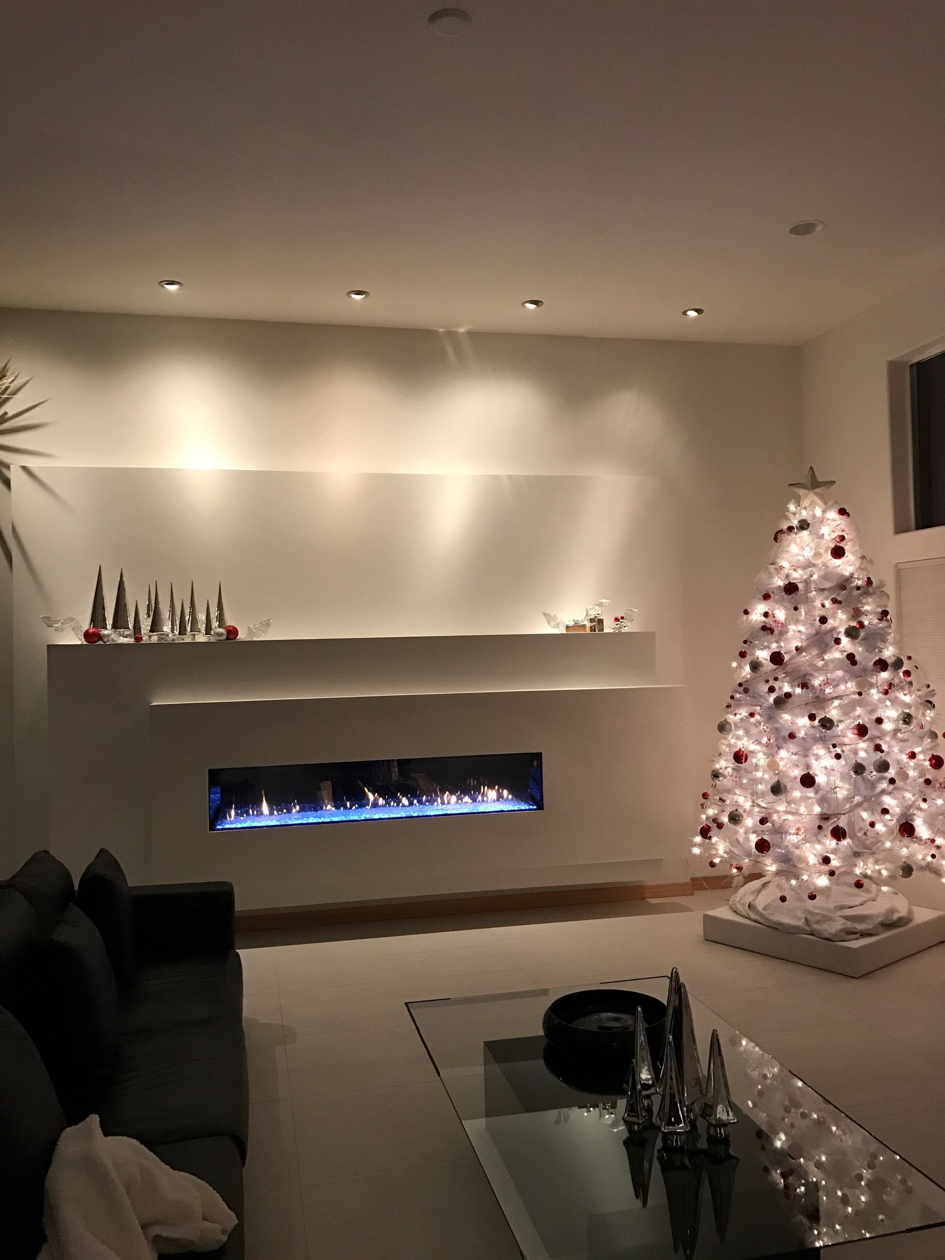 A living room with a christmas tree and a fireplace