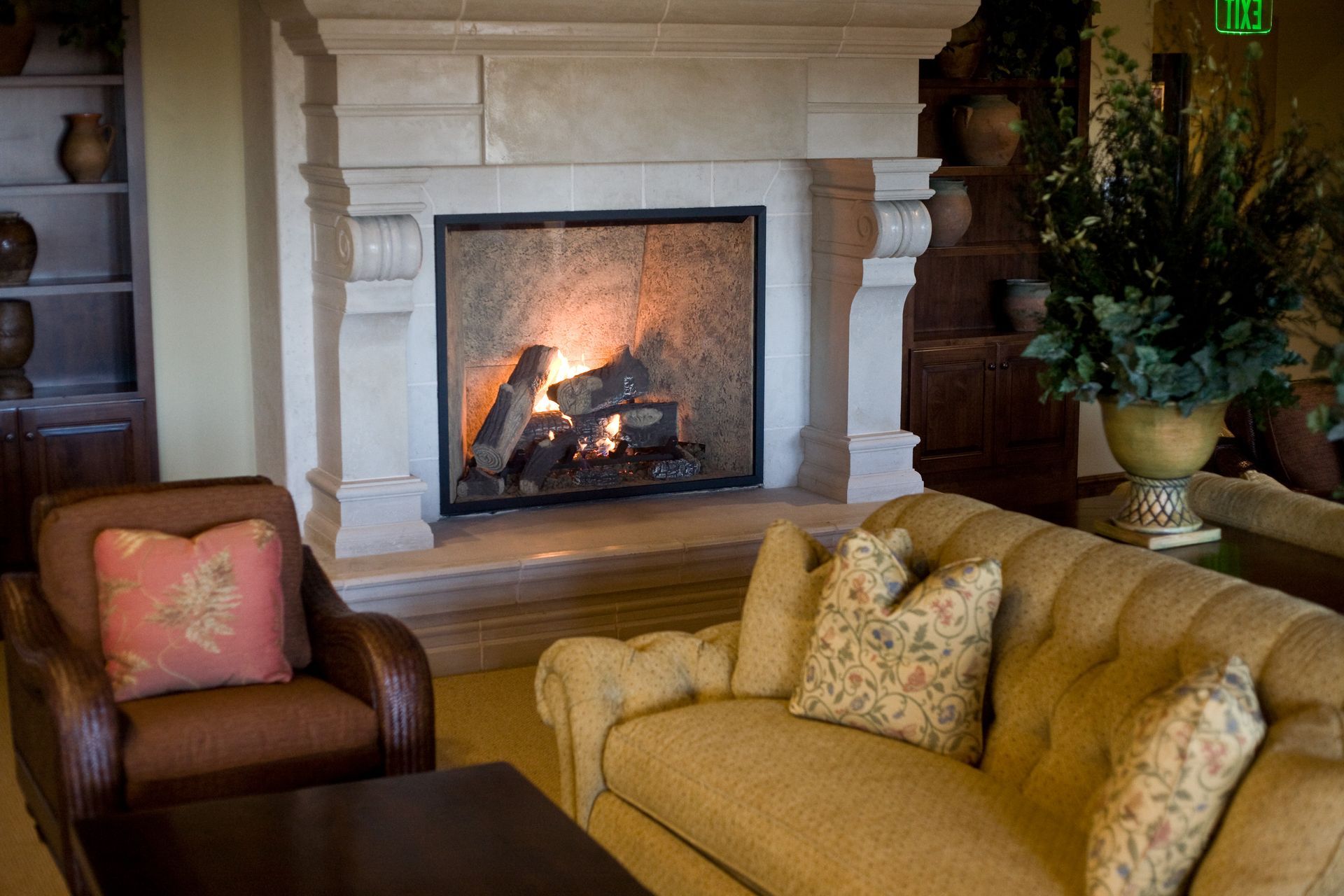 A living room with a fireplace , couch , chair and table.