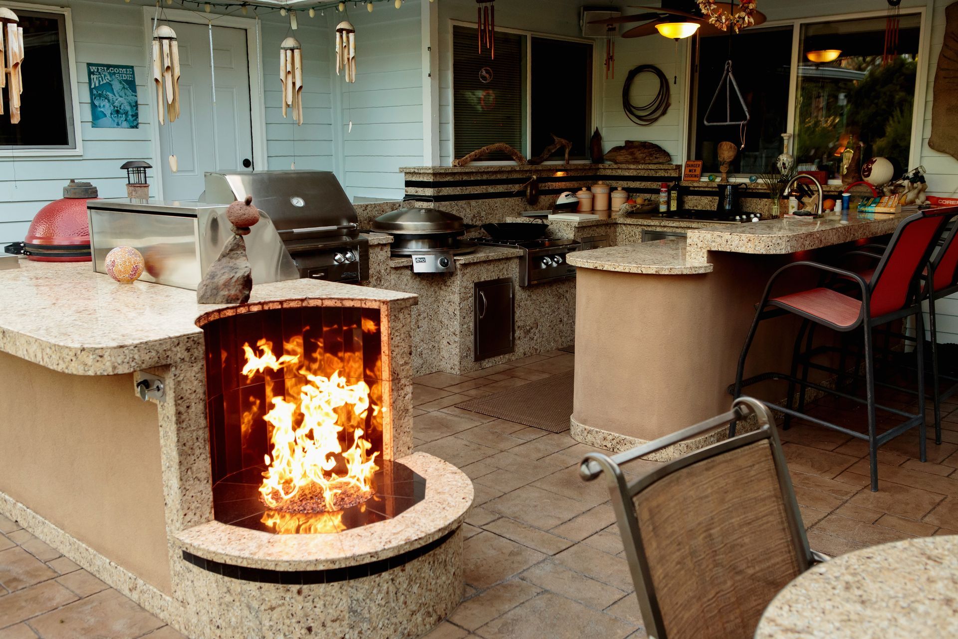 An outdoor kitchen with a fire pit and a grill