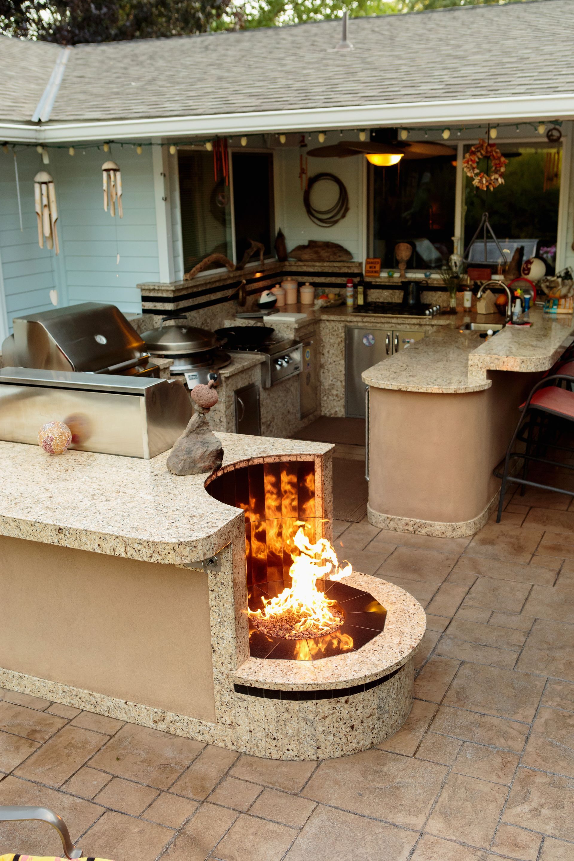 A kitchen with a fire pit in the middle of it